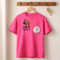 Pink t-shirt with 'CK's Prints' logo and a cat illustration on a wooden hanger against a beige wall.