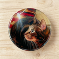 Round button badge with a cat design on a wooden surface